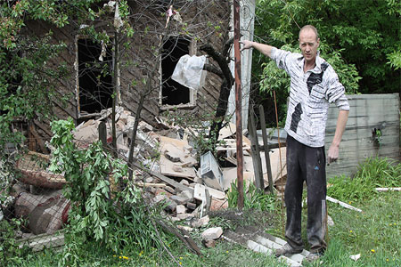 A man near a house damaged by shelling in Kuibyshevsky District of Donetsk May 10, 2017.