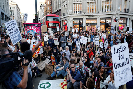 Demonstrators sit in the road in the West End, during a protest following the fire that destroyed The Grenfell Tower block, in north Kensington, West London, Britain June 16, 2017.