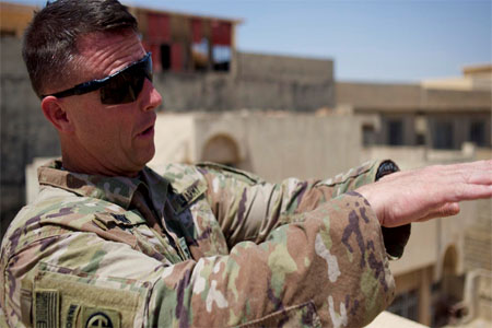 Colonel Pat Work of the US Army's 82nd airborne division looks at the skyline, as he meets with Iraqi commanders near the front lines, on the rooftop of a house in Mosul, Friday, June 30, 2017. (AP)