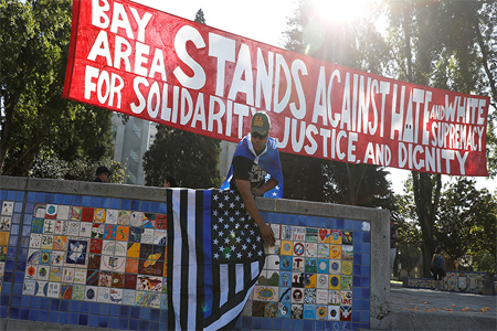 A supporter of U.S. President Donald Trump places a flag in Martin Luther King Jr. Civic Center Park ahead of a cancelled No Marxism in America event in Berkeley, California, U.S. August 27, 2017