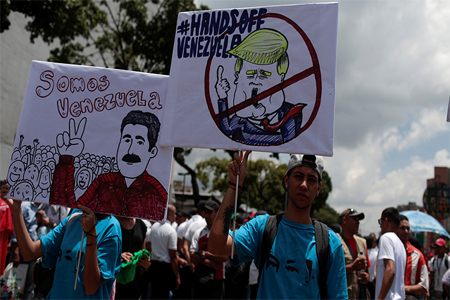 Supporters of Venezuela's President Nicolas Maduro hold placards depicting U.S. President Donald Trump and Venezuela's President Nicolas Maduro, that reads "We are Venezuela"