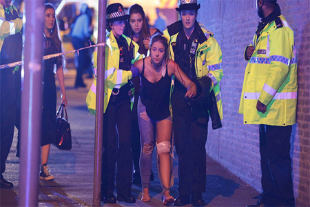 An injured concert-goer is helped by police and emergency responders at the Manchester Arena after reports of an explosion, Manchester, England