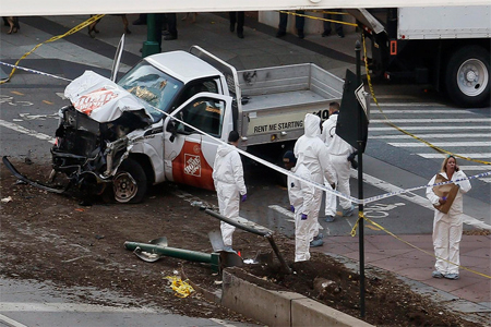 Authorities stand near a damaged Home Depot truck after a motorist drove onto a bike path near the World Trade Center memorial, striking and killing several people Tuesday.