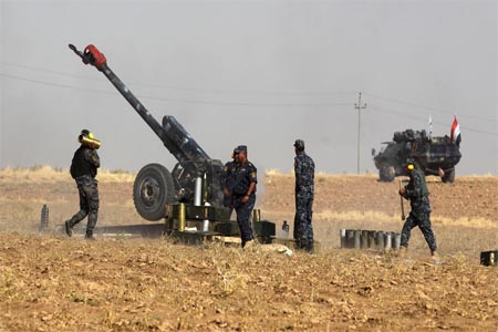 Iraqi forces manning an artillery gun as they fire against Kurdish Peshmerga positions near the area of Faysh Khabur.