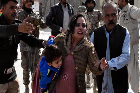 A policeman guides a family after gunmen attacked the Bethel Memorial Methodist Church in Quetta, Pakistan.
