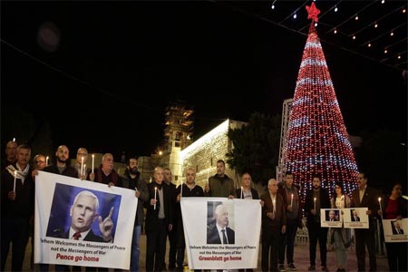 Palestinians hold posters showing US Vice President Mike Pence during a protests against his visit near the Church of the Nativity in the West Bank city of Bethlehem, on Dec. 17, 2017.