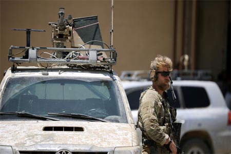 U.S army soldier stands guard next to an armored vehicle in Tabqa, Syria June 29, 2017