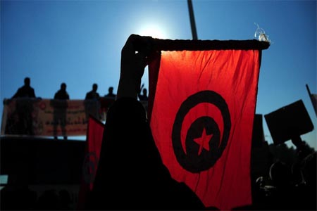 Tunisian police officers wave the national flag and posters as they demonstrate outside the presidential palace in Carthage near Tunis.