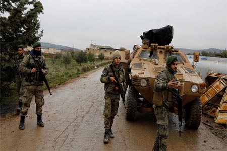 Members of Turkey-backed Free Syrian Army police forces secure the road as they escort a convoy near Azaz, Syria January 26, 2018.