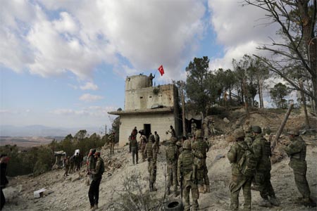 Turkish forces wave a flag on Mount Barsaya, northeast of Afrin, Syria, on January 28, 2018.