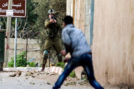 A Palestinian protester confronts an Israeli soldier during an army search operation in the Palestinian village of Burqin in the northern occupied West Bank, on February 3, 2018