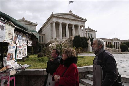 يونانيون يتابعون أخبار الصحف أمام المكتبة الوطنية في آثينا اليوم