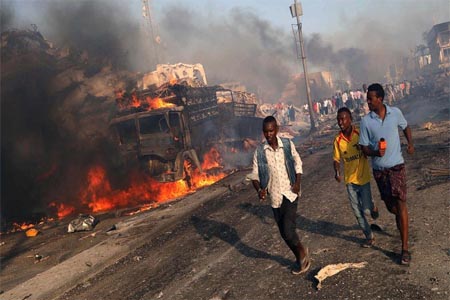 Civilians evacuate from the scene of an explosion in KM4 street in the Hodan district of Mogadishu, Somalia.