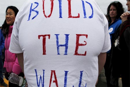 “The border wall is truly our first line of defense,” Trump told reporters.