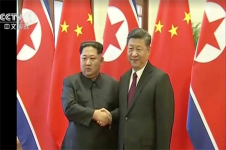 North Korean leader Kim Jong Un shakes hands with Chinese President Xi Jinping, in this still image taken from video released on March 28, 2018.
