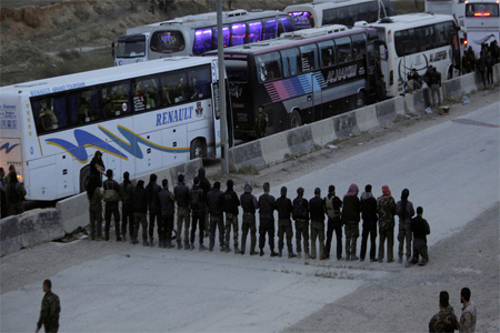 Rebel fighters pray before they are evacuated outside Harasta in eastern Ghouta, March 23, 2018
