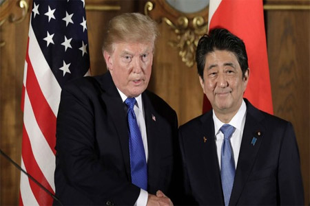 ترمب يصافح رئيس الوزراء الياباني