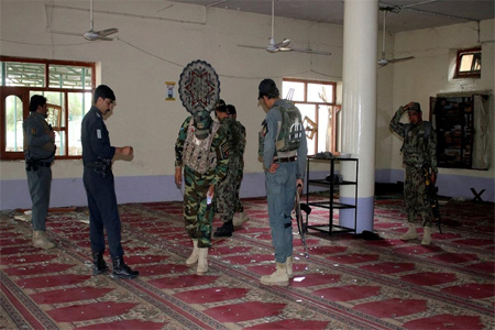 Afghan policemen inspect a mosque after a blast in Khost province.
