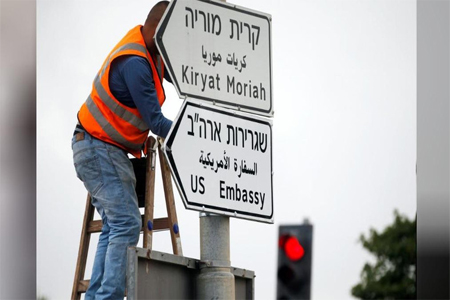 A worker hangs a road sign directing to the U.S. embassy, in the area of the U.S. consulate in Jerusalem, May 7, 2018.
