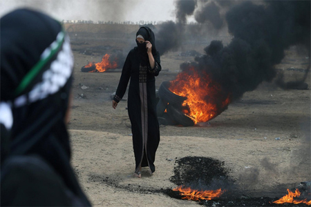 Female Palestinian demonstrator walks during a protest against US embassy move to Jerusalem.