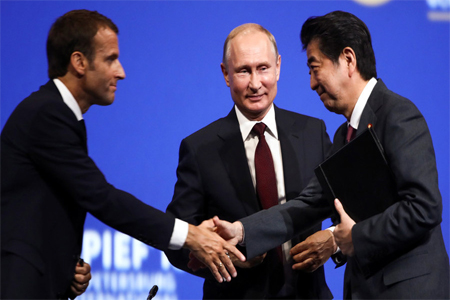 French President Emmanuel Macron, Russia's Vladimir Putin and Shinzo Abe of Japan at the St. Petersburg International Economic Forum.