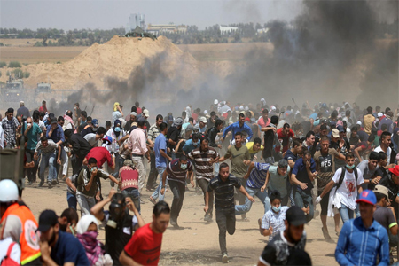 Palestinian demonstrators run for cover from Israeli gunfire during the protest in southern Gaza Strip on June 8, 2018