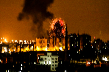 An explosion is seen in Gaza City after an airstrike by Israeli forces on June 18, 2018.
