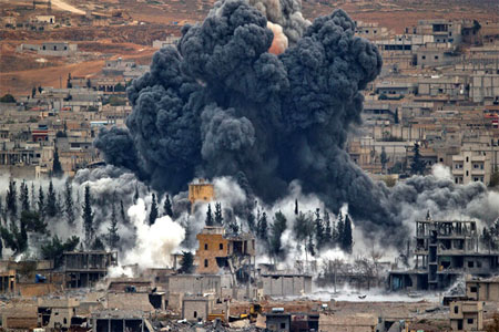 In this Nov. 17, 2014 file photo, smoke rises from the Syrian city of Kobani, following an airstrike by the U.S.-led coalition, seen from a hilltop outside Suruc, on the Turkey-Syria border. (AP)