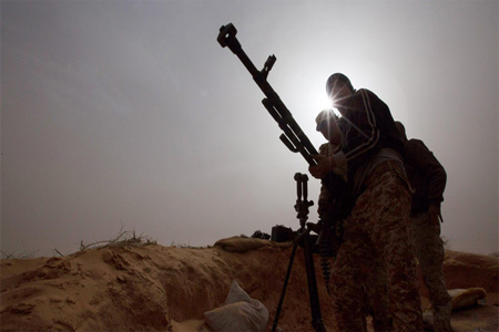 In this Saturday, Feb. 21, 2015 photo, Libyan soldiers try to fix a weapon that jammed during clashes with militants on the frontline in Al Ajaylat, west of Tripoli, Libya. (AP)