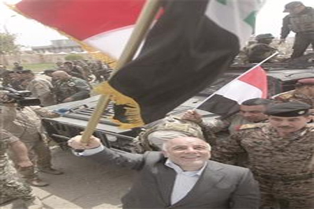 العبادي يرفع العلم العراقي خلال زيارته لتكريت، أمس. (أ ف ب)