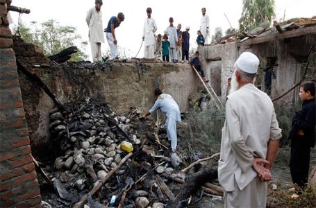 Afghans inspect a damaged house after a drone crash last night in Jalalabad.(Reuters / Parwiz )