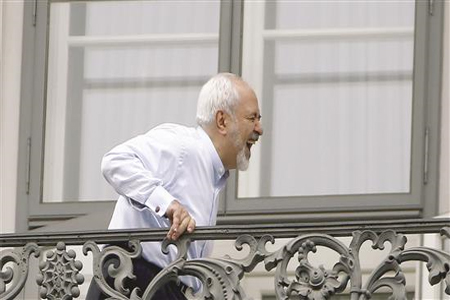 ظريف ضاحكاً من على شرفة قصر كوبورغ الذي تعقد فيه جلسات التفاوض حول الملف النووي الإيراني في فيينا، أمس (رويترز)