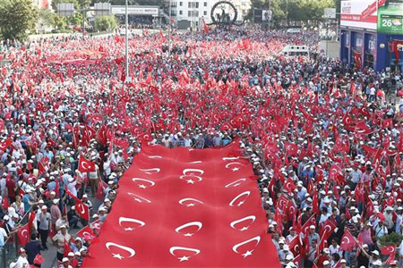 أتراك يحملون علماً كبيراً خلال تظاهرة ضد الإرهاب في أنقرة امس الاول (ا ف ب)