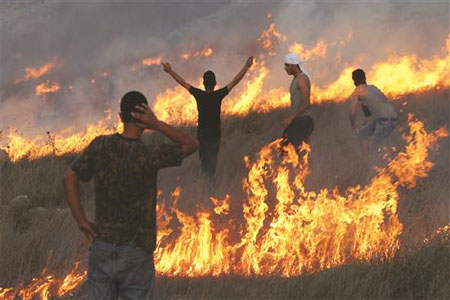 فلسطينيون خلال مواجهات مع قوات الاحتلال والمستوطنين الذين احرقوا البساتين في قرية بورين في الضفة الغربية المحتلة (أ ف ب)