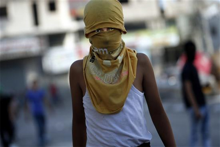 فلسطيني خلال المواجهات مع الاحتلال في مخيم شعفاط في القدس المحتلة أمس الأول (ا ف ب)