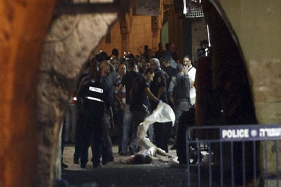 الأمن الإسرائيلي يغطي أحد المستوطنين بعد طعنه من قبل فلسطيني بالقدس القديمة (أسوشيتد برس)