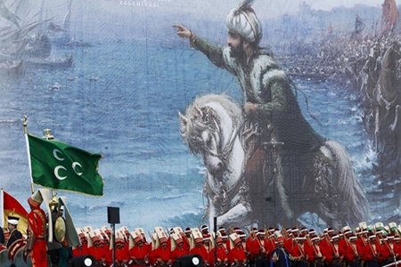 جنود أتراك بالزي العسكري العثماني يقفون أمام صورة السلطان العثماني محمد الثاني (الفاتح) في اسطنبول - تركيا، 30 مايو 2015