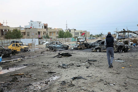 A man looks at the site where a car packed with explosives blew up, Baghdad, Iraq February 17, 2017.