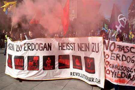 People hold banners and flags during a demonstration against Erdogan dictatorship and in favour of democracy in Turkey in Bern
